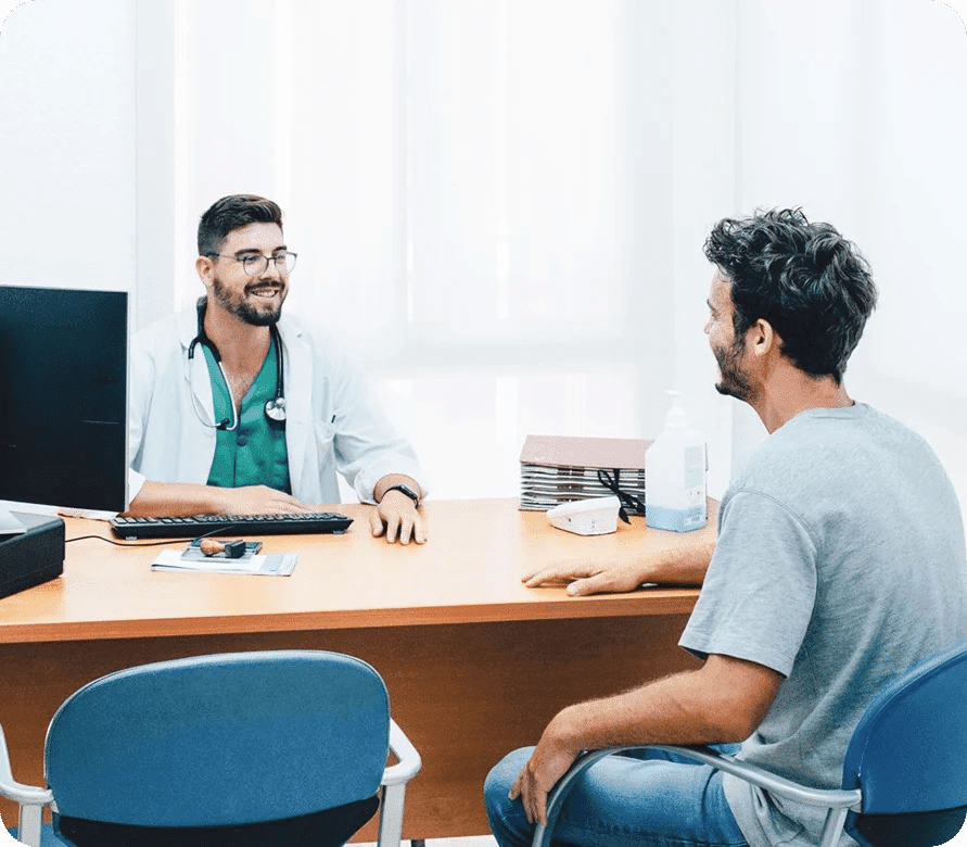 Doctor consulting with a male patient in a clinic, representing medical advice, diagnosis discussion, and support for Bowel Cancer screening and treatment.
